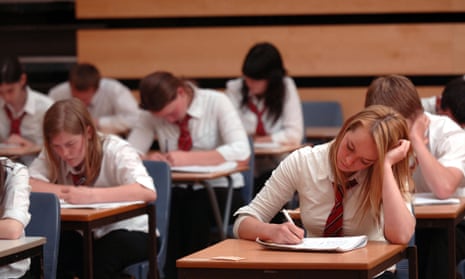 British school pupils in exam conditions in a school hall.