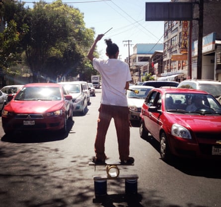 A juggler street artist entertaining drivers at a red light in Mexico City.