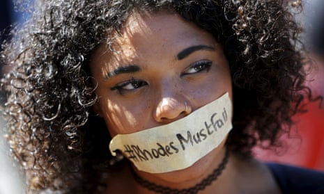 A student wears a sticker calling for the removal of a statue of Cecil John Rhodes from the campus of the University of Cape Town.