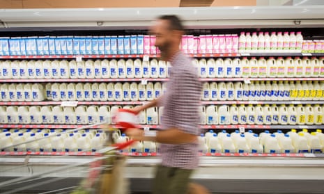 A shopper walks past bottles of milk