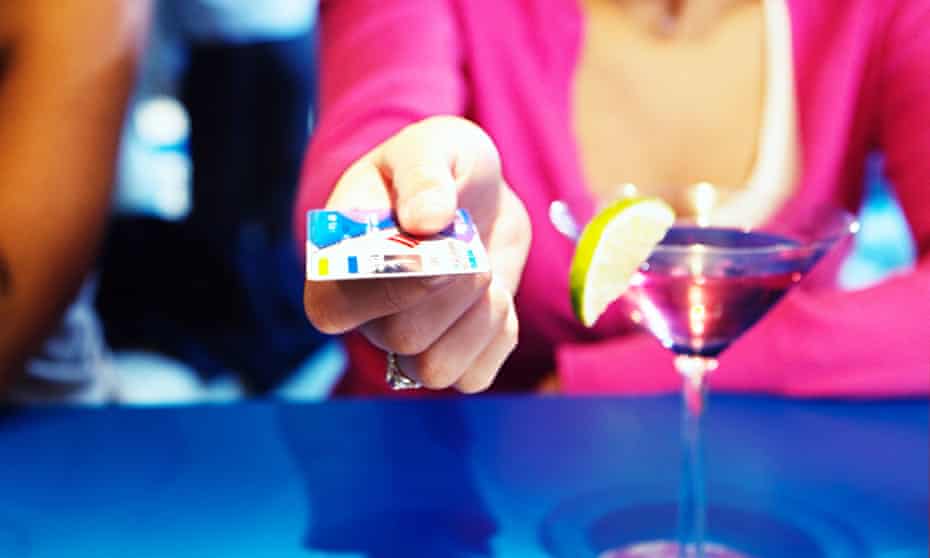 Woman handing credit card over bar