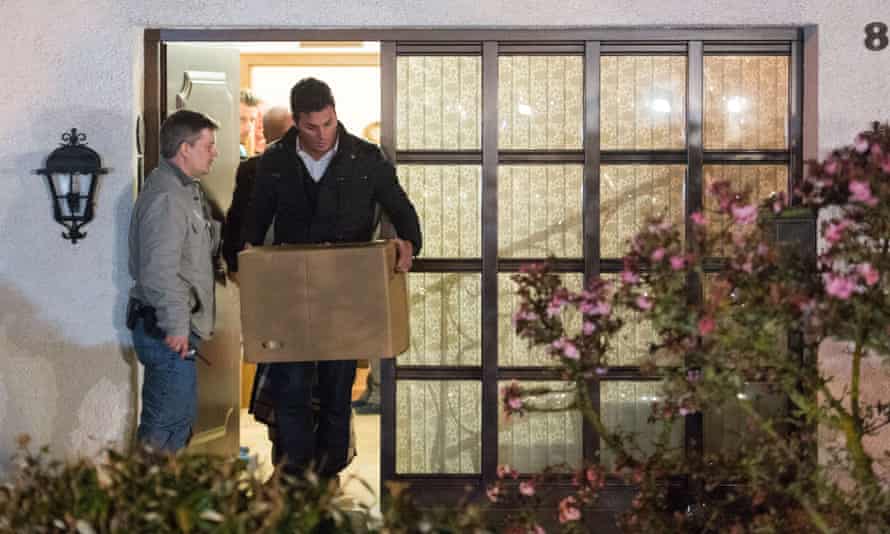Police carry computer, a box and bags out of the residence of the parents of Andreas Lubitz.