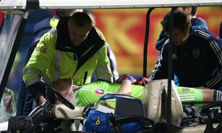 Igor Akinfeev is carried off on a stretcher after being hit on the head by a flare in the first minute.