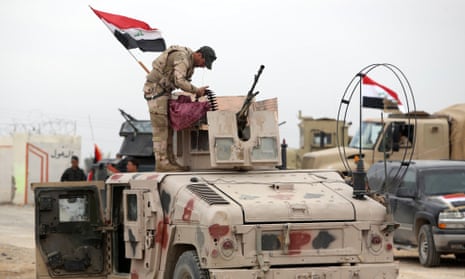 A member of the Iraqi security forces stands atop a military vehicle outside the western entrance of the city of Tikrit on 28 March.