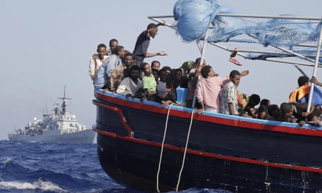 Some of more than 900  illegal migrants, are shipped to the mainland after being rescued by Italian Navy boat 'Fregata Euro'  (background) in the Mediterranean Sea, 12 September 2014.  