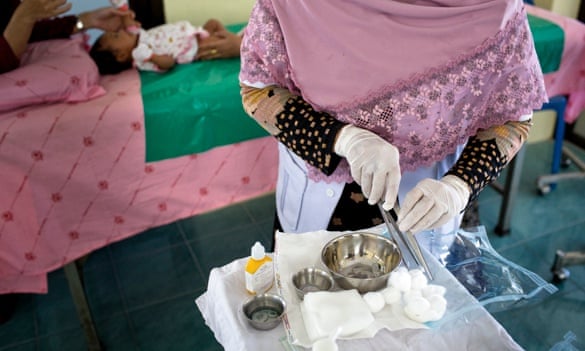 The midwife at the clinic in Pattani prepares the tools to cut eight-week-old Amiyah. 