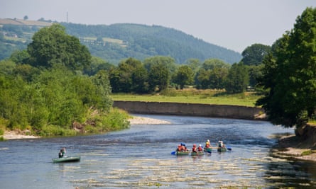 Child and adult canoeists paddling down the river Wye