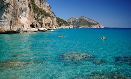 Kayaks sailing the clear transparent waters of the Mediterranean in Sardinia.