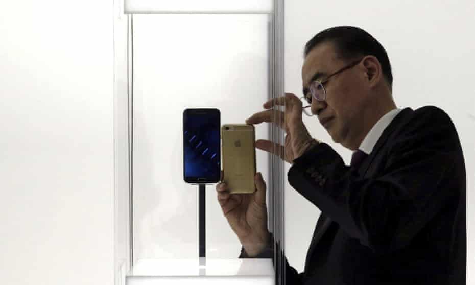 visitor uses his Apple iPhone to take a picture of the new Samsung Galaxy 6 smartphone at GSM Mobile World Congress in Barcelona 