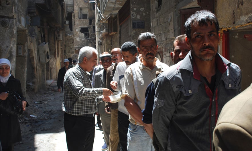 Palestine refugees in Yarmouk queue for food distributed by UNRWA.