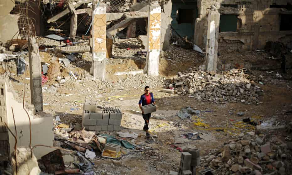 A Palestinian young man amid the rubble of destroyed buildings in the Gaza Strip