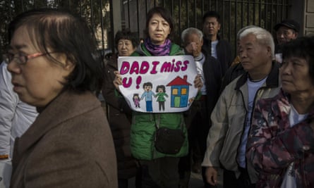 Beijing, China: Catherine Gang, whose husband is missing on flight MH370, holds a sign as she and other relatives protest outside the Malaysia Embassy on Sunday.