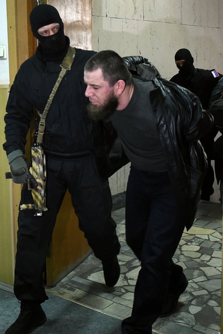 Tamerlan Eskerkhanov is taken into court by a policeman. Esterkhanov said he was at work at the time of Nemtsov's murder and had witnesses who could prove it.