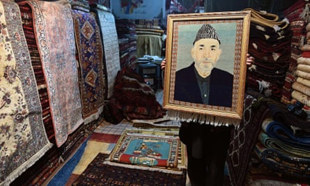 A Kabul trader displays a carpet bearing the image of former president Hamid Karzai.