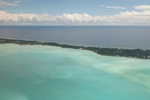 1. An aerial view of Tarawa, the capital of Kiribati, at high tide. The island lies only a couple of metres above sea level and at high tide almost disappears into the ocean. More than half of Kiribati's 100,000 people live in South Tarawa in an area of just over 10  km2, giving it a population density comparable to London.remigallery