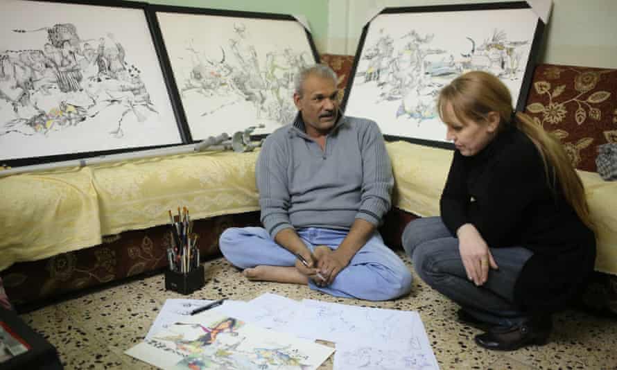 Akeel Korsheed, surrounded by his drawings, with filmmaker  Furat al-Jamil