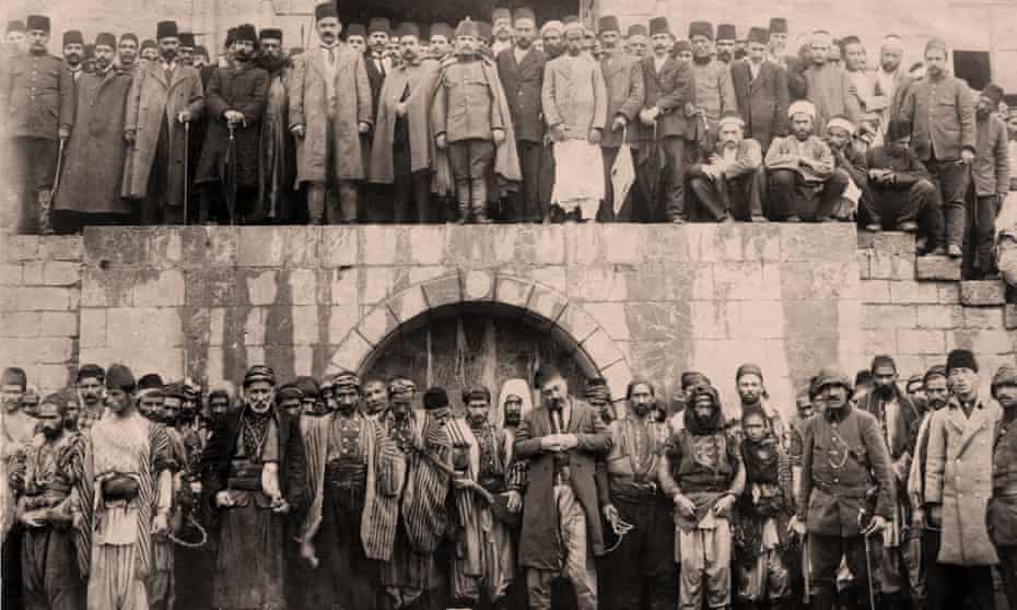 Armenians at the Marash army barracks awaiting execution. (Bottom row)  Above them, the Ottoman governor, Haydar Pasha, and soldiers. April 1915.