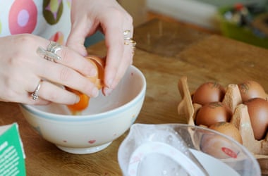 cracking eggs into a bowl to check their freshness
