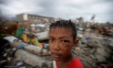 Typhoon Haiyan survivor Joshua Cator, 11, scavenging for food and reusable material in destroyed houses.