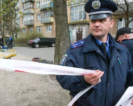 A police officer cordons off the area as police experts examine the body of prominent pro-Russian journalist Oles Buzyna.