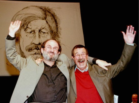 Günter Grass, right, and Salman Rushdie wave to the crowd in front of a portrait of Grass, during his 70th birthday party in Hamburg's Thalia theatre, October 1997.