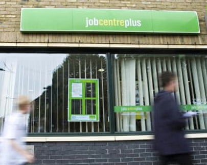 Job seekers walk past a jobcentre