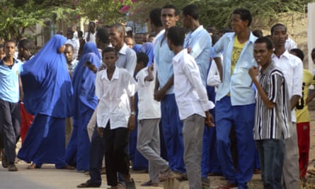 Students gather and watch from a distance outside the Garissa University College.