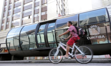A cyclist passes a Bus Rapid Transit (BRT) stop in Curitiba, Brazil.
