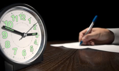 clock with a man doing written test in the background,useful for job application.education and other testing related