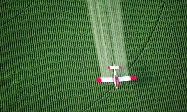 A crop duster sprays farmland