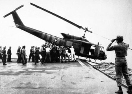 29 April 1975: US navy personnel aboard the USS Blue Ridge push a helicopter into the sea off the coast of Vietnam in order to make room for more evacuation flights from Saigon.