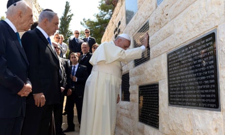 Pope Frances puts his hands on a plaque at Mount Herzl cemetery in Jerusalem honouring victims of terrorism