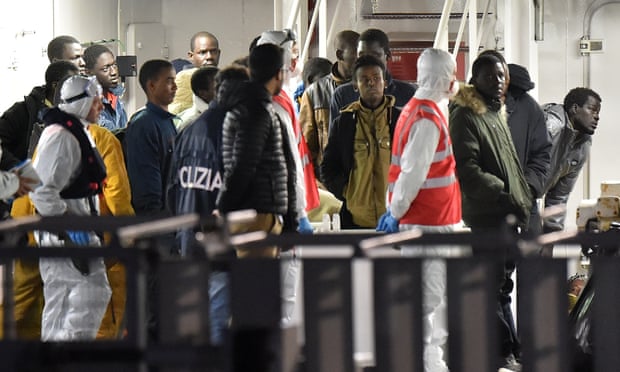 Libyan migrants stand on the deck of an Italian coastguard ship