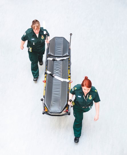 Two NHS workers push an empty trolley