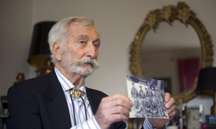 At home in Houilles, holding up a photo of the members of his unit during the second world war.