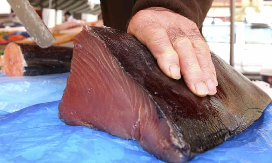 A fishmonger cuts a joint of Bluefin tuna, which was caught off of Thailand. The European Union is to give Thailand six months to drastically change its policies on illegal and unregulated fishing or face an EU fish import ban. 