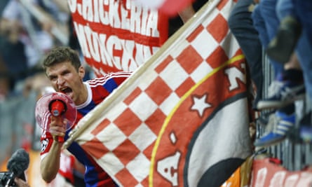 Bayern's Thomas Müller celebrates with fans after the game.