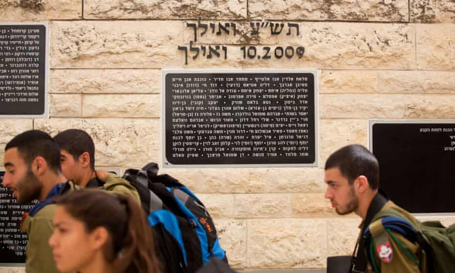 Israeli soldiers on Tuesday walk past the memorial stone in Hebrew bearing the name of Mohammed Abu Khdeir
