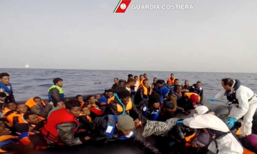 Italian coast guard personnel rescue shipwrecked migrants off the coast of Sicily