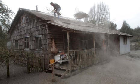 A man shovels ash from Calbuco volcano off the roof of his home in Ensenada, Chile.