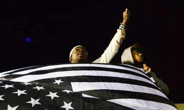Protesters display a flag as demonstrations continue  over Freddie Gray's death in Baltimore police custody.