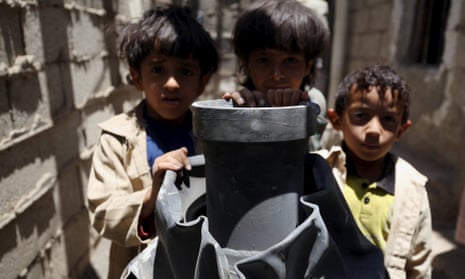 Children stand next to a shell which landed on their house from a nearby missile base after the base was struck by a Saudi-led coalition air strike, near Sanaa April 23, 2015.