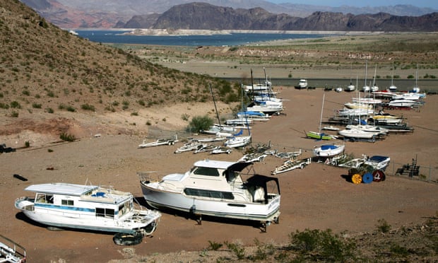 Lake Mead is seen in the distance behind boats in dry dock near the Lake Mead Marina in Nevada.