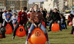 people bounce on orange Spacehoppers 