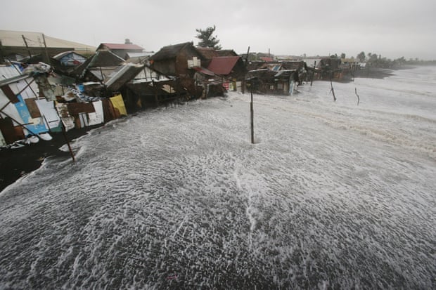 Waves crash into coastal houses as typhoon Hagupit pounds Legazpi, Albay province, eastern Philippines in December 2014. 