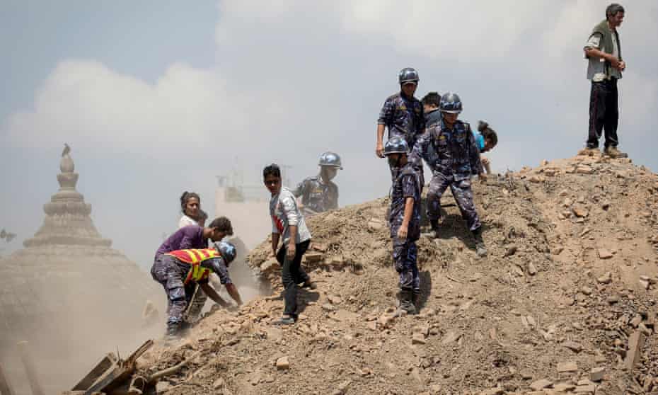 Nepalese police personnel and volunteers clear the rubble while looking for survivors at the compound of a collapsed temple, following the earthquake in Kathmandu, Nepal.