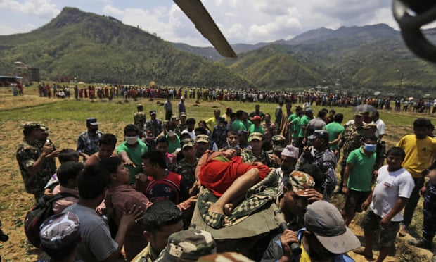 Nepalese soldiers carry a wounded woman to a waiting Indian air force helicopter as they evacuate victims from Trishuli Bazar to Kathmandu airport.