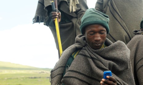 Lesothan shepherd using a mobile telephone