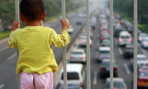 A child looks at a congested Beijing road. During the 2008 Olympics the government raised emissions standards and slashed the number of vehicles on the road.