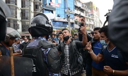 Nepalese police push back residents who began protesting after waiting for hours in line to board buses from Kathmandu.